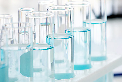 Reagenzgläser mit hellblauer Flüssigkeit gefüllt im Labor