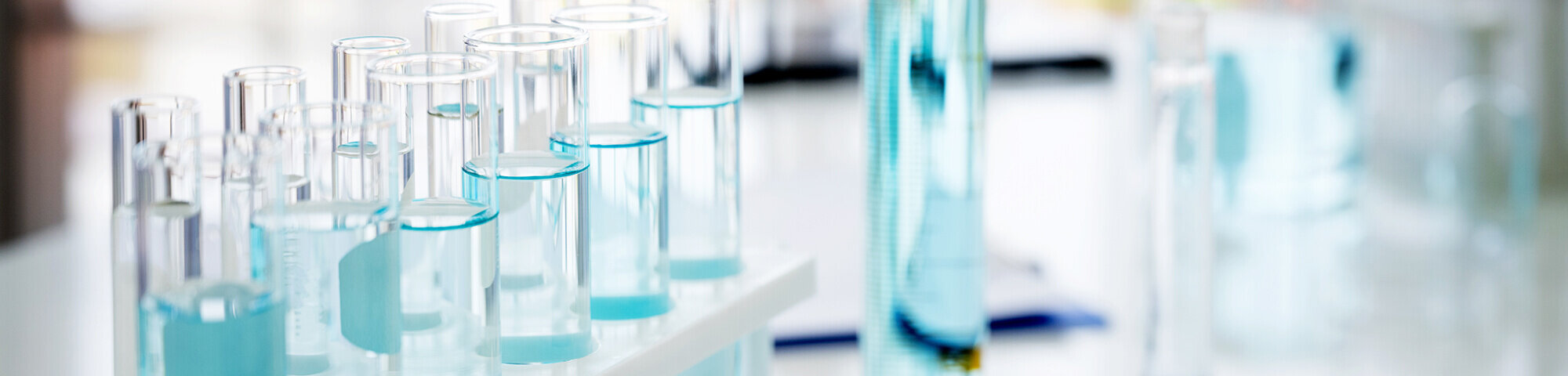 Reagenzgläser mit hellblauer Flüssigkeit gefüllt im Labor