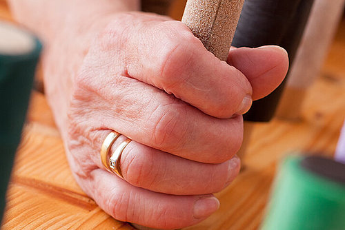 Seniorin greift nach Holzstift bei Ergotherapie